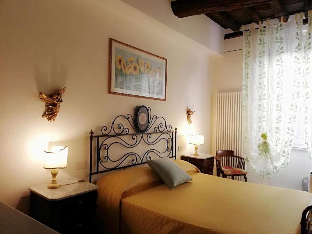 um quarto com uma cama com 2 candeeiros e 2 cadeiras em B&B Alle Due Porte em Siena