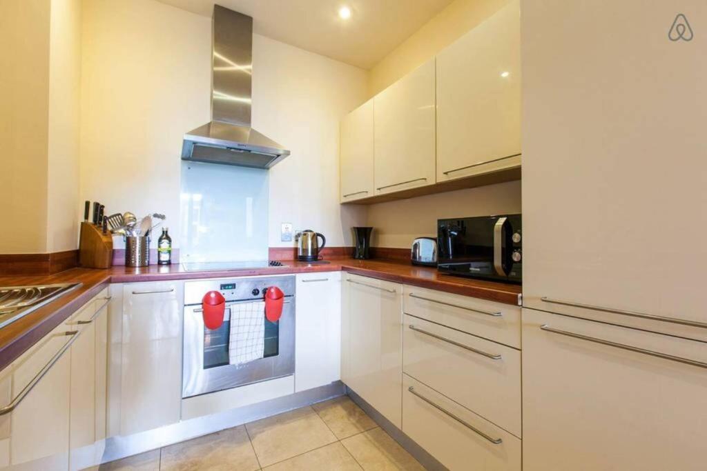 uma cozinha com armários brancos e um forno com placa de fogão em The Forum A2B em Dublin