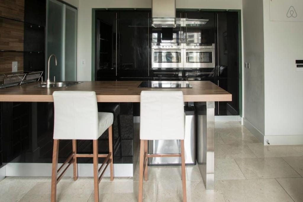a kitchen with a wooden table and two white chairs at The Edges A2B in Sandyford
