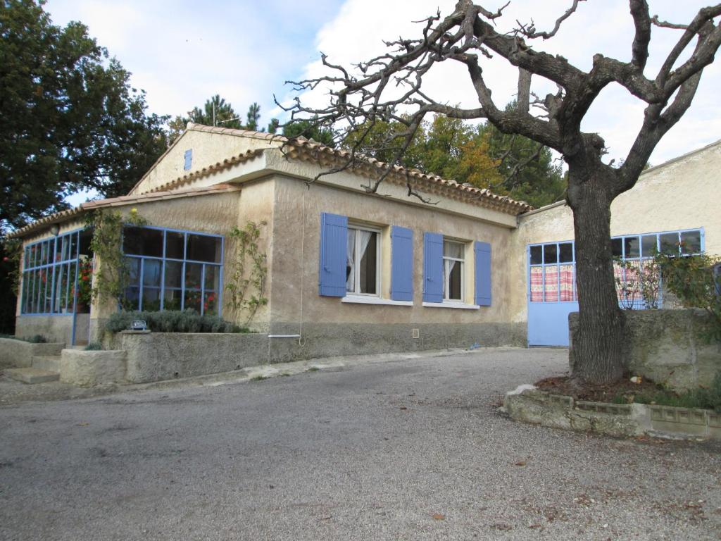 a house with a tree in front of it at Gîte des Géraniums in Crestet