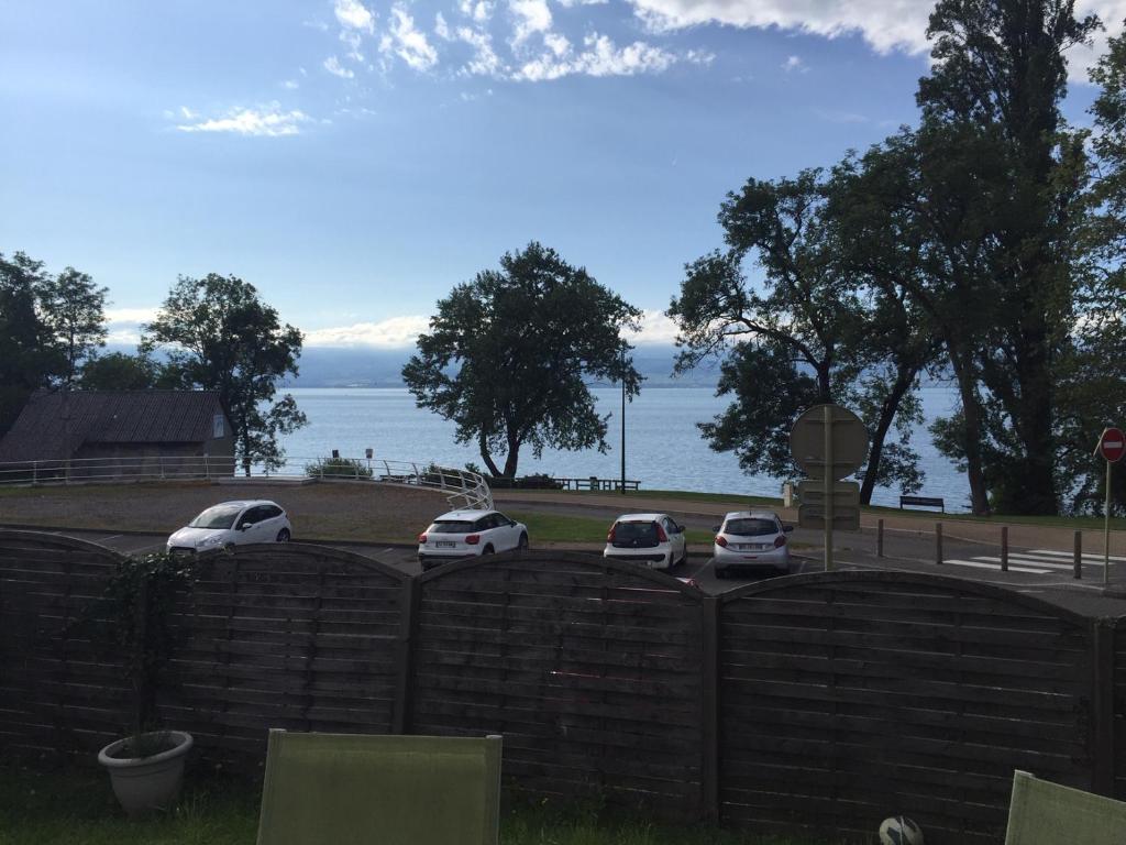 three cars parked in a parking lot next to the water at Appart Thonon Corzent au bord du Lac in Thonon-les-Bains