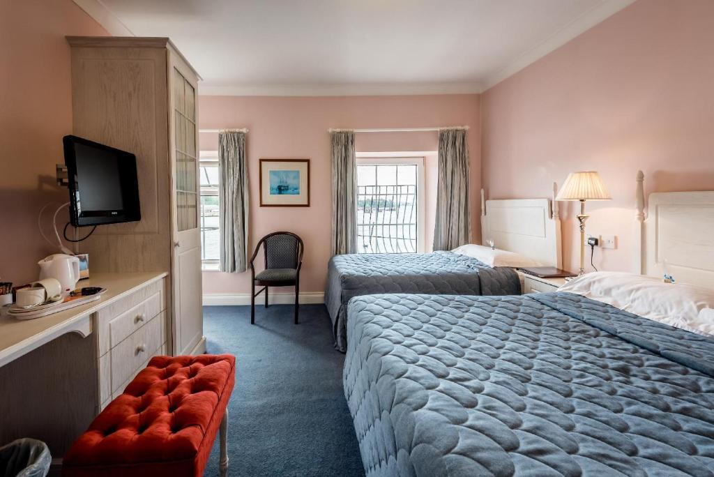 um quarto de hotel com duas camas e uma televisão em The Bosun em Monkstown