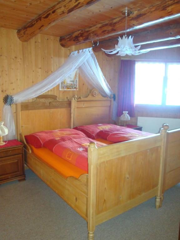 um quarto com uma cama de madeira e um dossel em Bellahof em Flumserberg