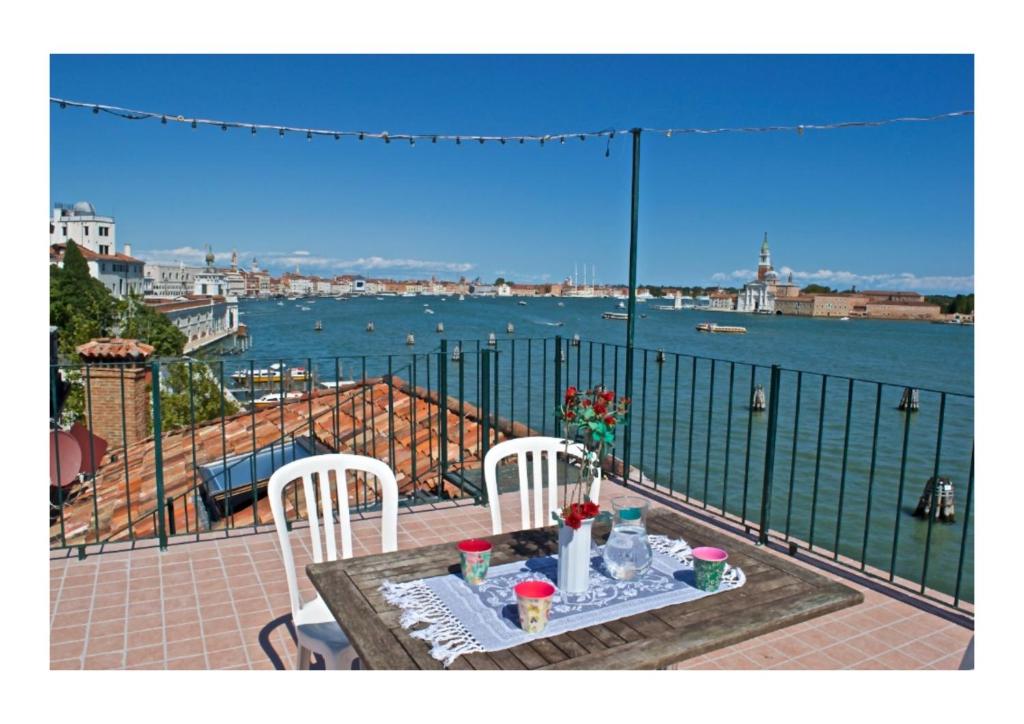 una mesa y sillas en un balcón con vistas al agua en Mimi's loft en Venecia