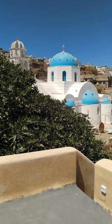 vista su un edificio con cupole blu di Santorinio Yellow House a Éxo Goniá
