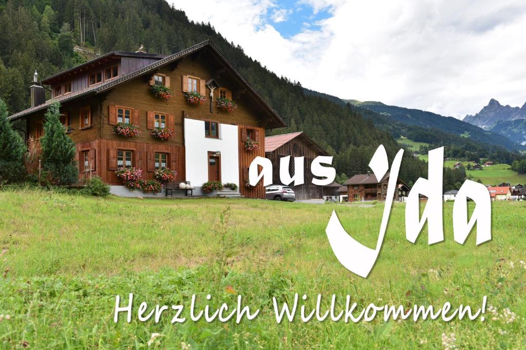 ein Haus auf einem Feld vor einem Berg in der Unterkunft Haus Ida in Schruns-Tschagguns