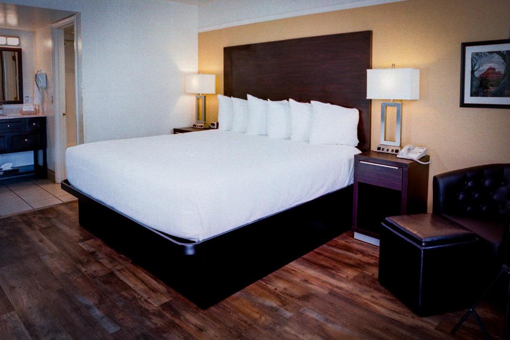 Postel nebo postele na pokoji v ubytování Pines Inn & Suites