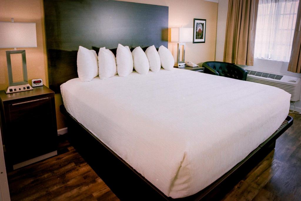 Postel nebo postele na pokoji v ubytování Pines Inn & Suites