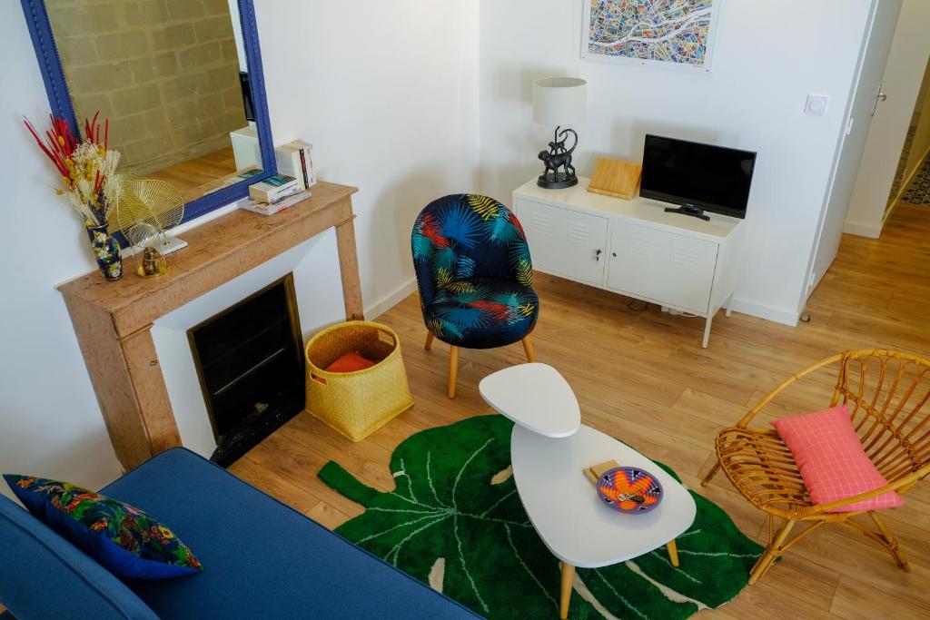 sala de estar con sofá azul y sillas en Duplex de charme quartier Opéra Graslin en Nantes