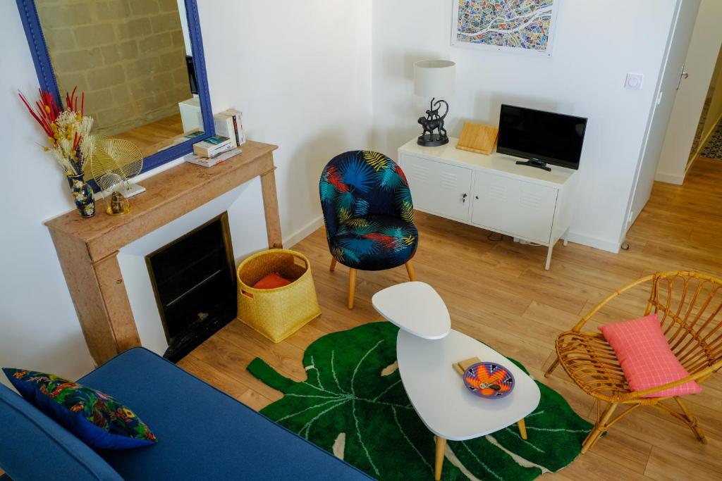 un salon avec un canapé bleu et des chaises dans l'établissement Duplex de charme quartier Opéra Graslin, à Nantes