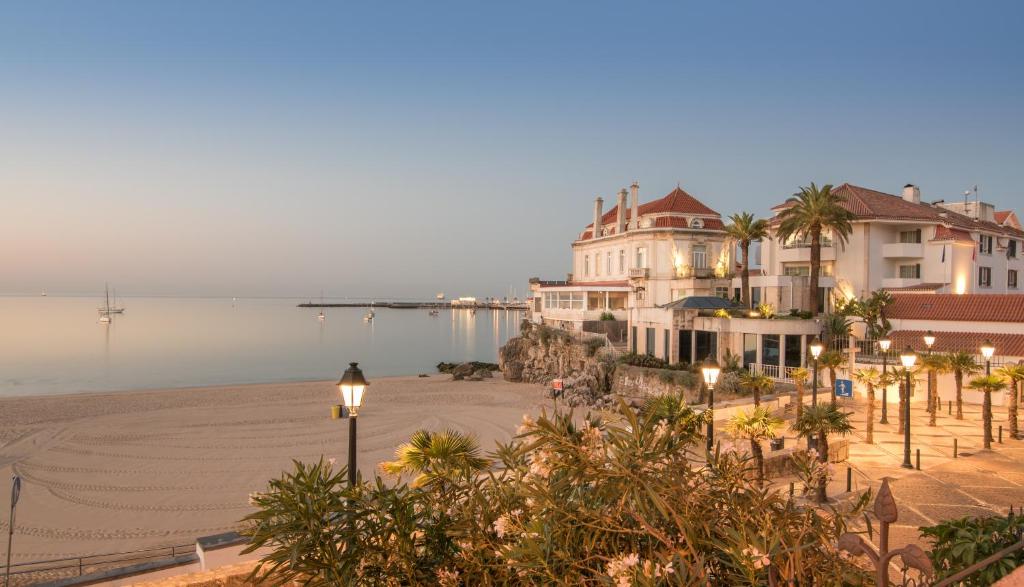 a view of a beach with buildings and the water at The Albatroz Hotel in Cascais