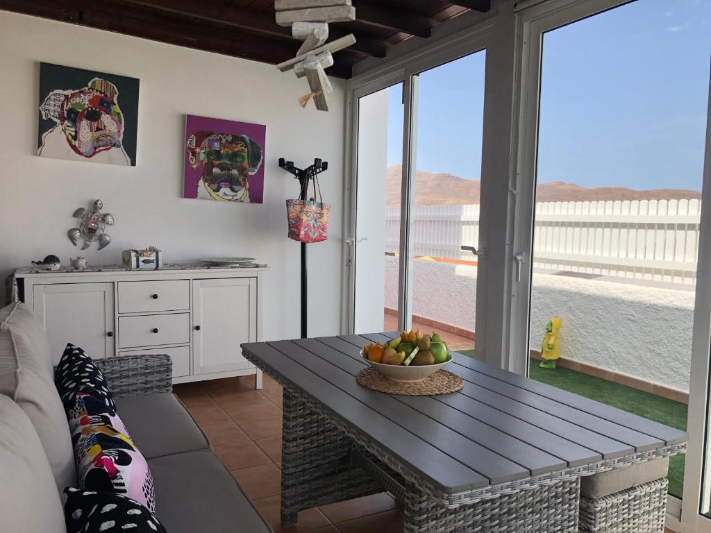 a living room with a table with a bowl of fruit on it at Villa CarpeDiem Tarajalejo in Tarajalejo