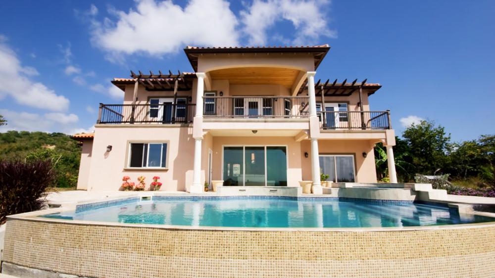 a house with a large swimming pool in front of it at Emerald Vista Villa in Vieux Fort