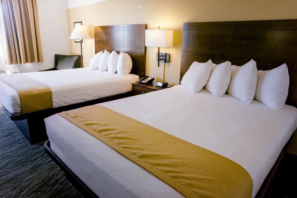 Postel nebo postele na pokoji v ubytování Pines Inn & Suites