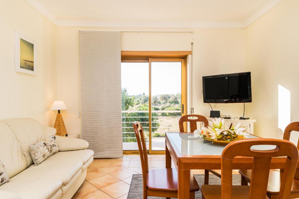 a living room with a white couch and a table at HouseLuz in Armação de Pêra