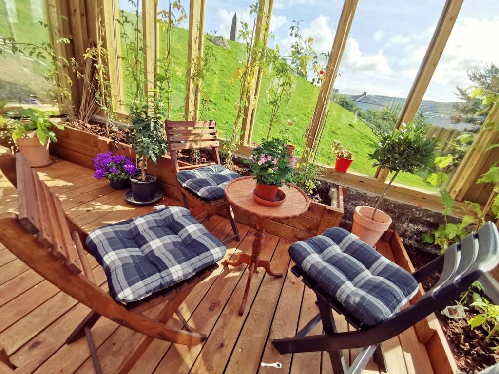 a porch with chairs and a table with plants at A Green Pearl in the Heart of Tórshavn in Tórshavn