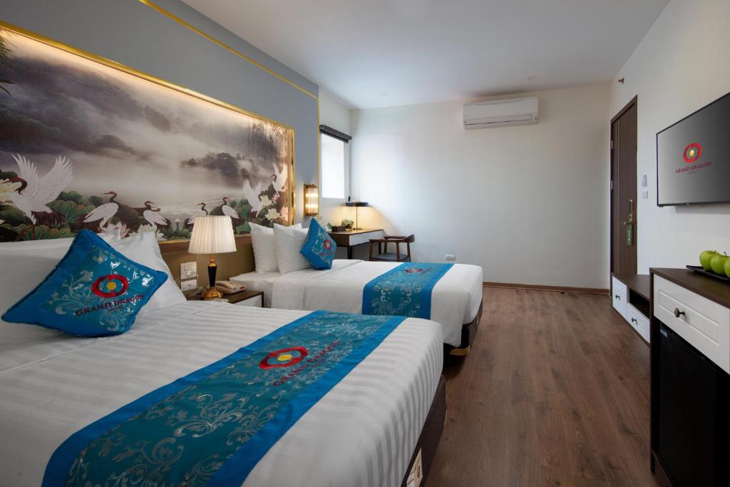 Postel nebo postele na pokoji v ubytování Grand Dragon Hotel Hanoi