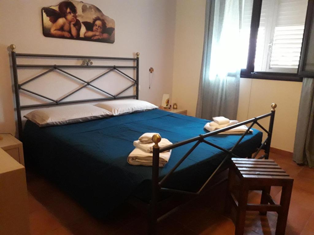 a bedroom with a bed with a blue comforter at 439 HOUSE in Marina di Ragusa