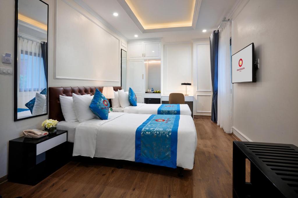 Postel nebo postele na pokoji v ubytování Grand Dragon Hotel Hanoi