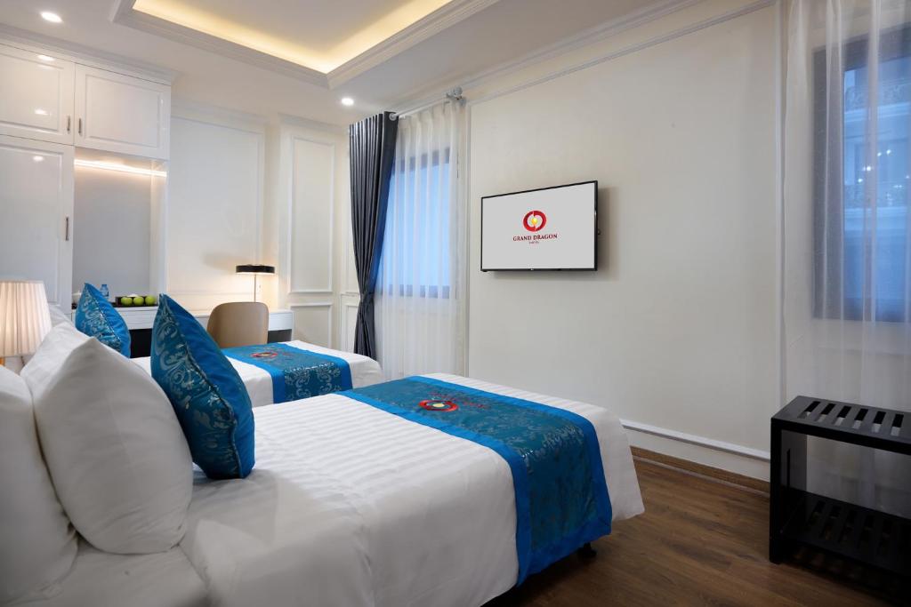 Postel nebo postele na pokoji v ubytování Grand Dragon Hotel Hanoi