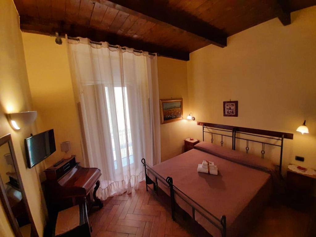 um quarto com uma cama, uma televisão e uma janela em B&B Conte Cavour em Nápoles