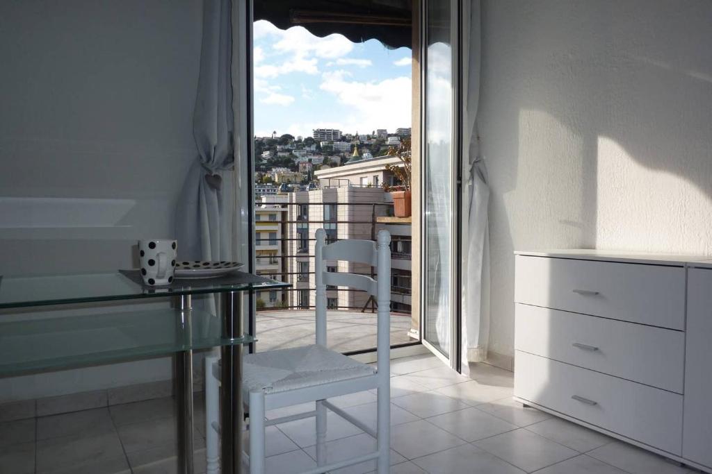 une table et une chaise dans une pièce avec une fenêtre dans l'établissement Nice Centre Studio Proche Mer, à Nice