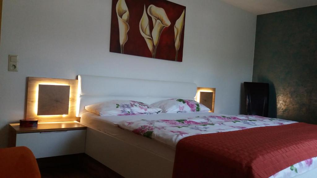 Un dormitorio con una cama con dos luces. en Ferienwohnung Rosentraum, en Oberotterbach