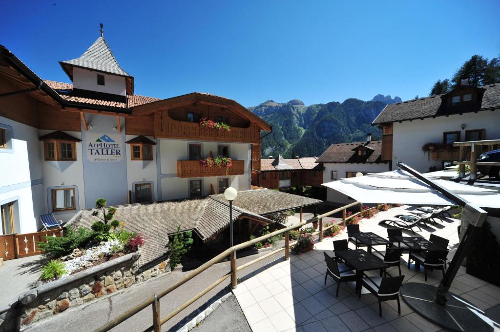 a hotel with a patio with tables and chairs at Alphotel Taller Wellness & Sport in Folgarida