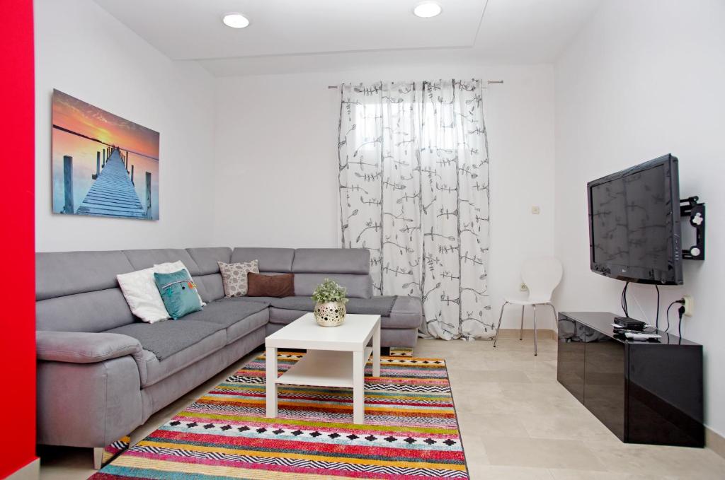 a living room with a couch and a tv at Apartments Armonia in Podstrana