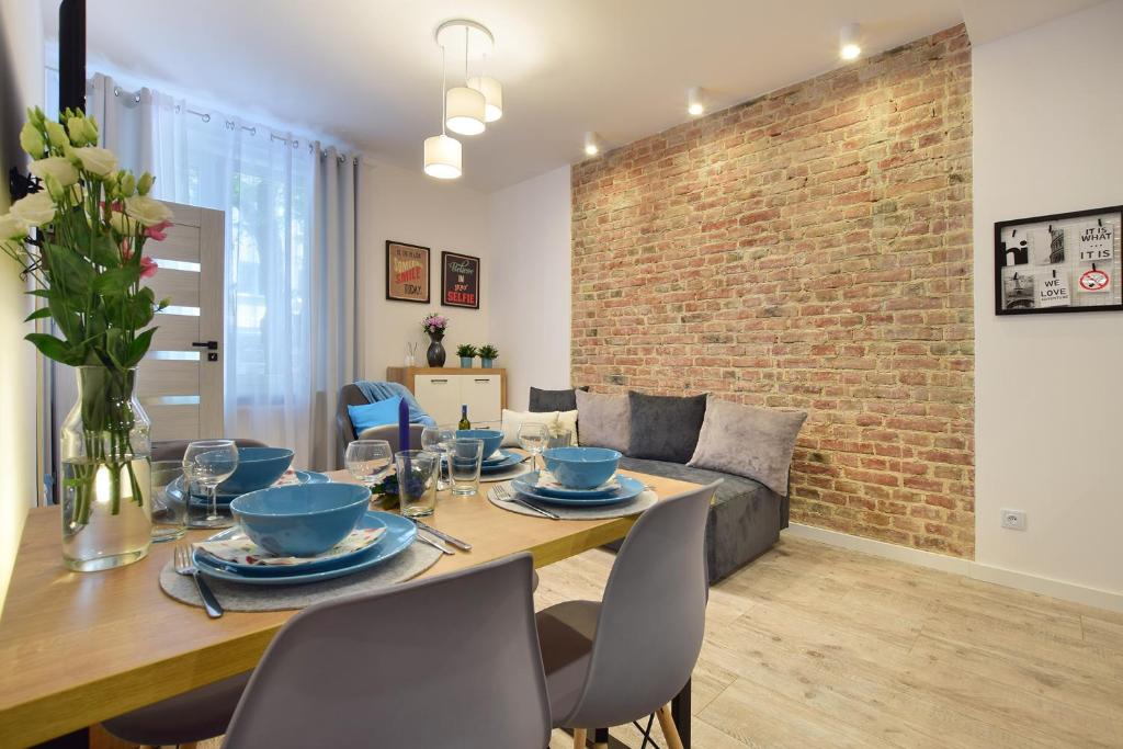 a dining room with a table and a brick wall at CityLife Business Apartament Centrum in Lublin