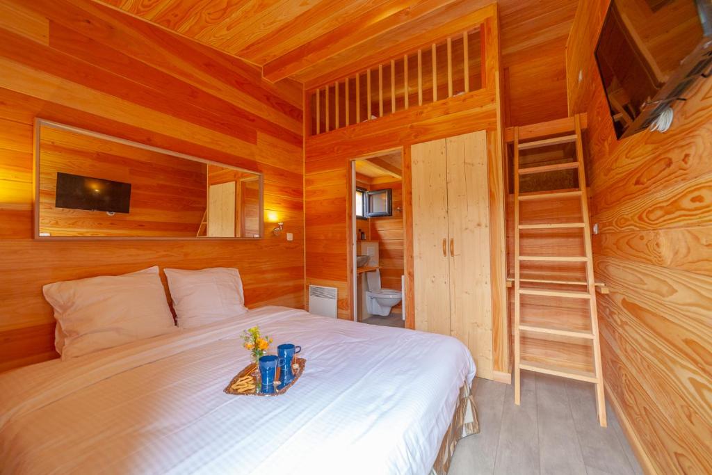 a bedroom with a bed in a wooden cabin at Le Moulin in Martres-Tolosane