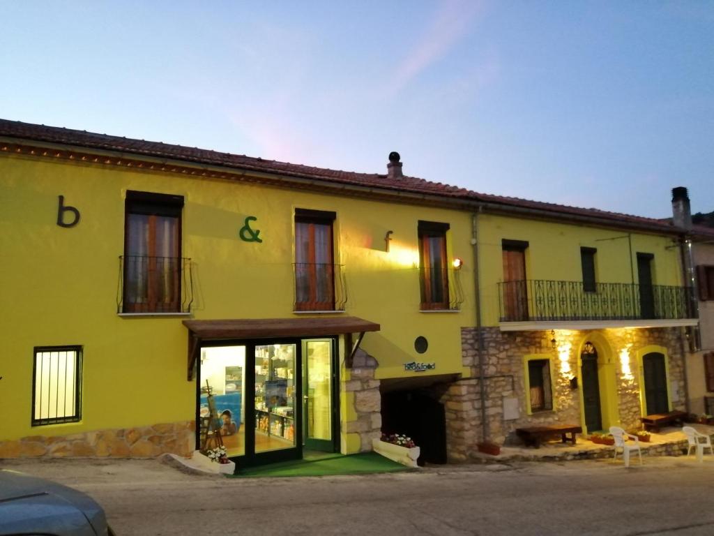 a large yellow building with a store front at Castelpetroso Bed&Food in Castelpetroso