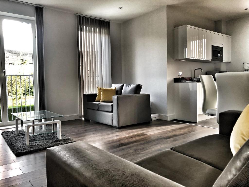 een woonkamer met een bank en een tafel bij Luxury 2 Bed 2 Bath Apartment 18 mins from Central London - SLEEPS 6 in Watford