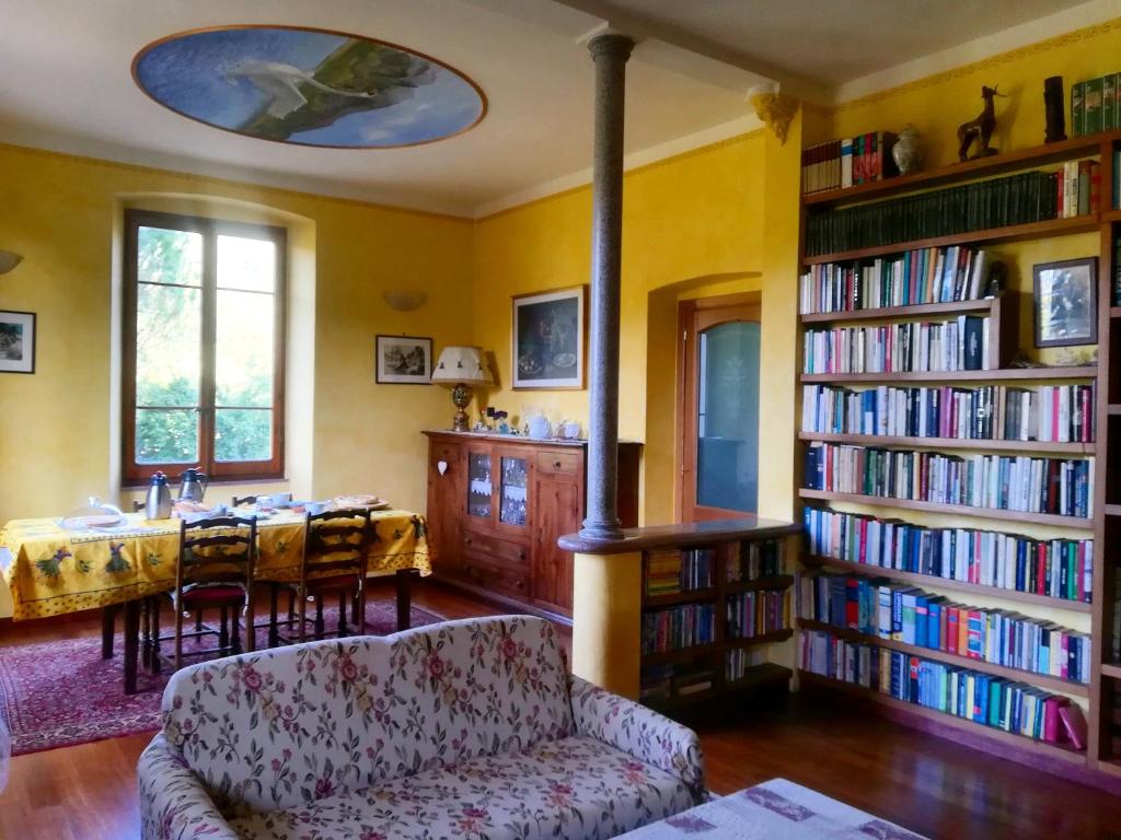 een woonkamer met een bank en een tafel met boeken bij Agriturismo A Trasea in Varese Ligure