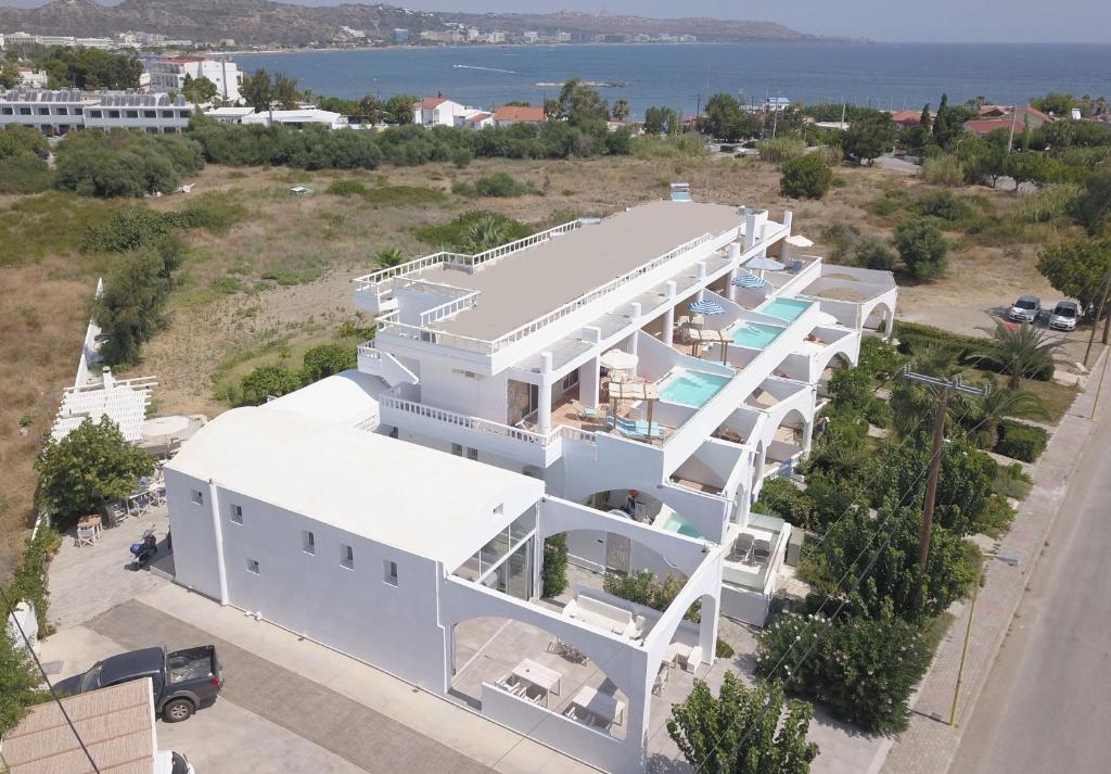 an aerial view of a white house with the ocean at Kathara Bay Apartments in Faliraki