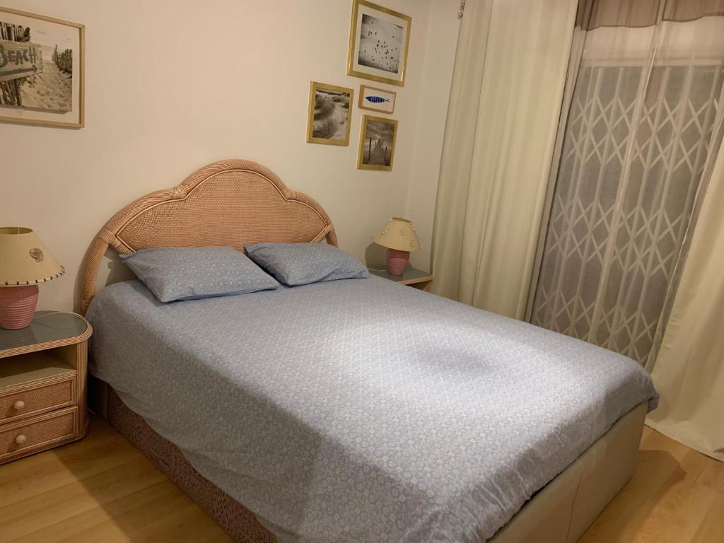 a bedroom with a bed and two lamps and a window at Sunny Beach Apartment Holidays in Vila do Conde
