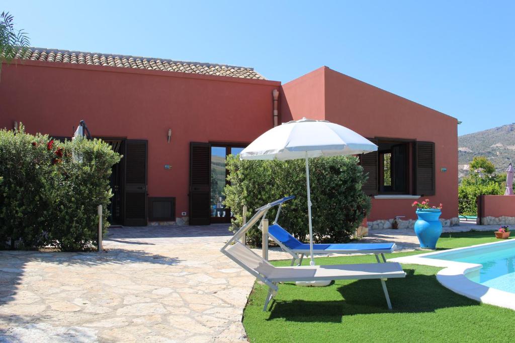 una sedia e un ombrellone accanto alla piscina di Casa Vacanze Al Basyta a Buseto Palizzolo