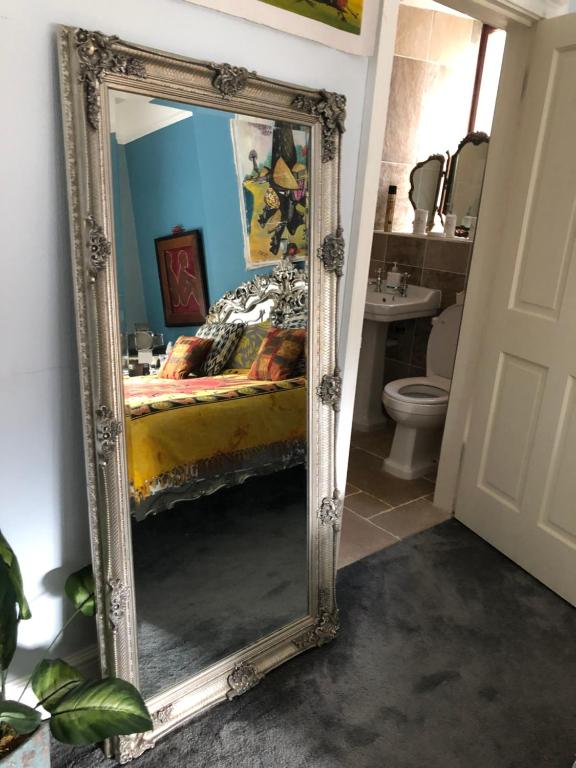 a mirror in a room with a bed and a bathroom at Belmont House Boutique - the Kingsley collection in Berwick-Upon-Tweed