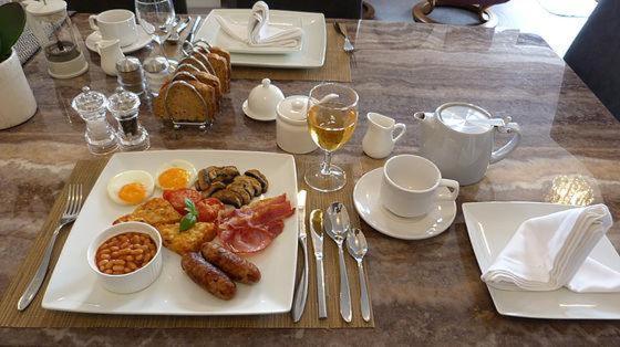 a table with a plate of breakfast food on it at Prestbury Bed & Breakfast in Salisbury