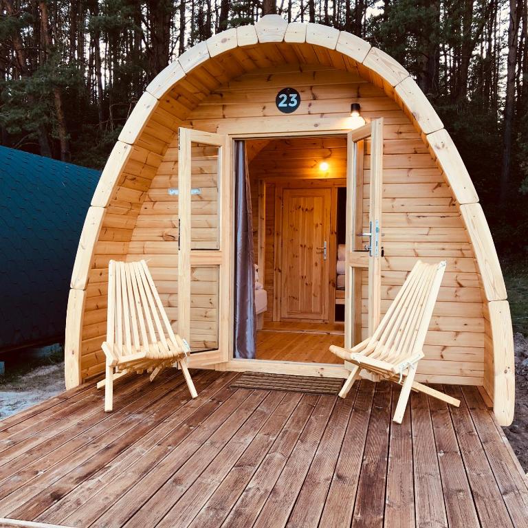 a sauna with two chairs on a wooden deck at Luxury Camping POD in Zarasai