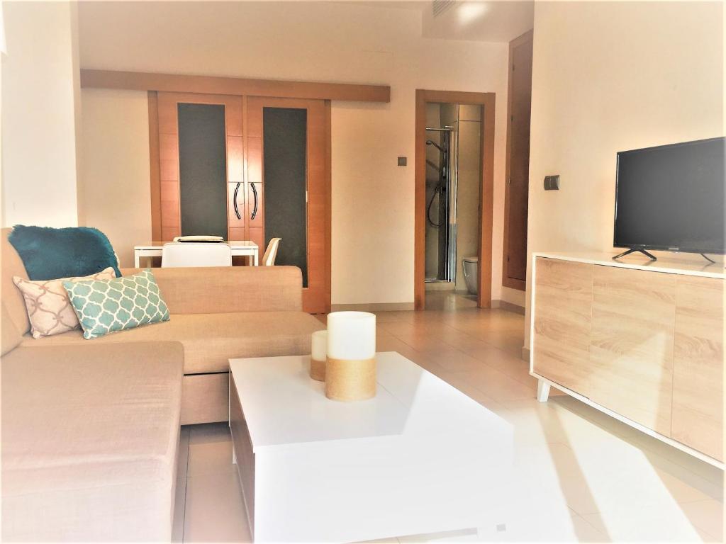 een woonkamer met een bank en een tv bij Be Suites Centro in Granada