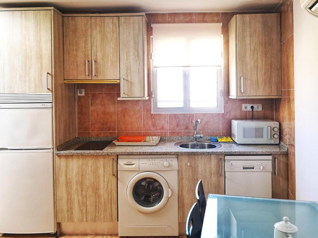 cocina con lavadora y microondas en Apartamentos Cocó, en Ávila