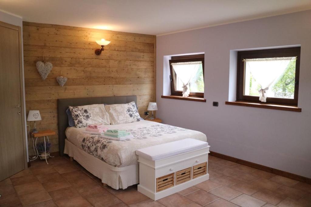 1 dormitorio con 1 cama y 2 ventanas en Appartamento La Torre, en Serina