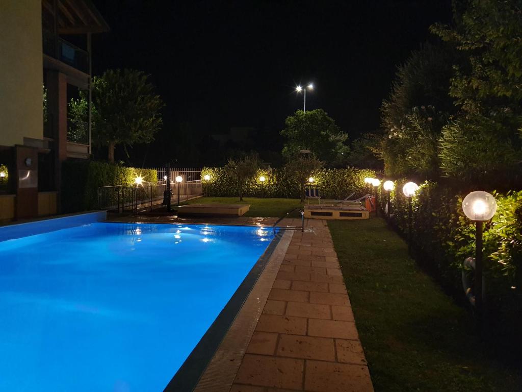 een zwembad met blauwe lichten in een tuin 's nachts bij garda felice in Desenzano del Garda