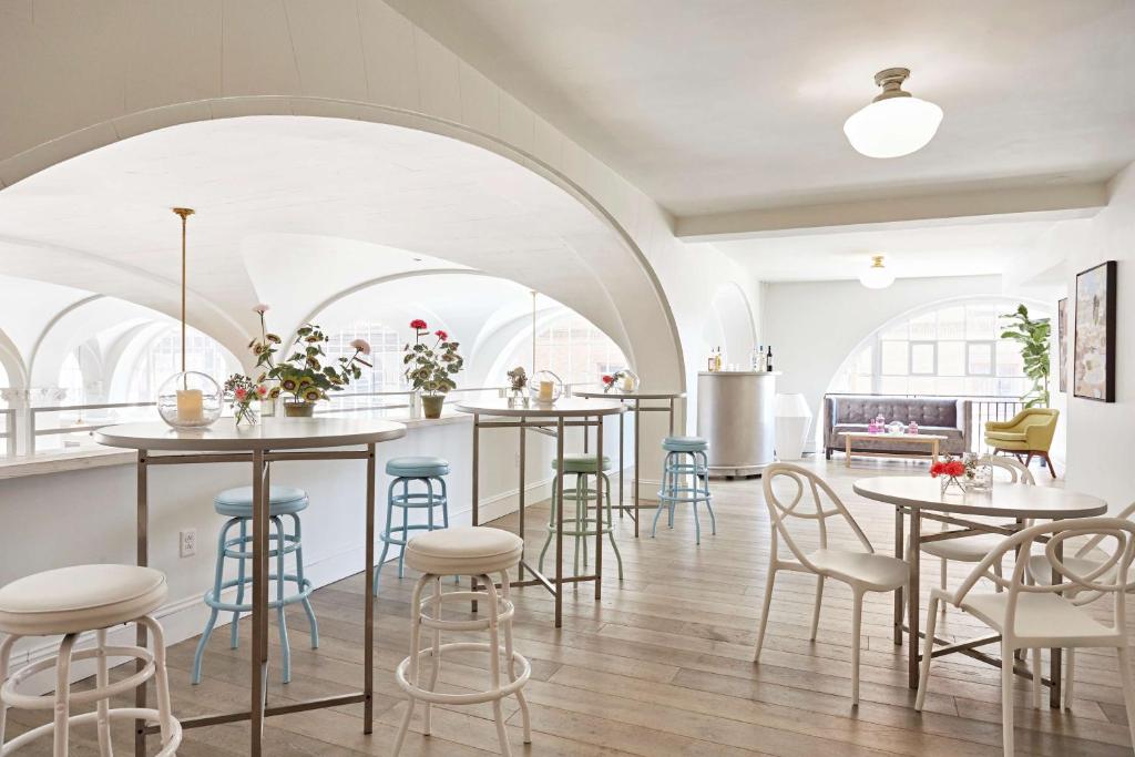 a room with tables and chairs and a kitchen at Quirk Hotel Richmond in Richmond