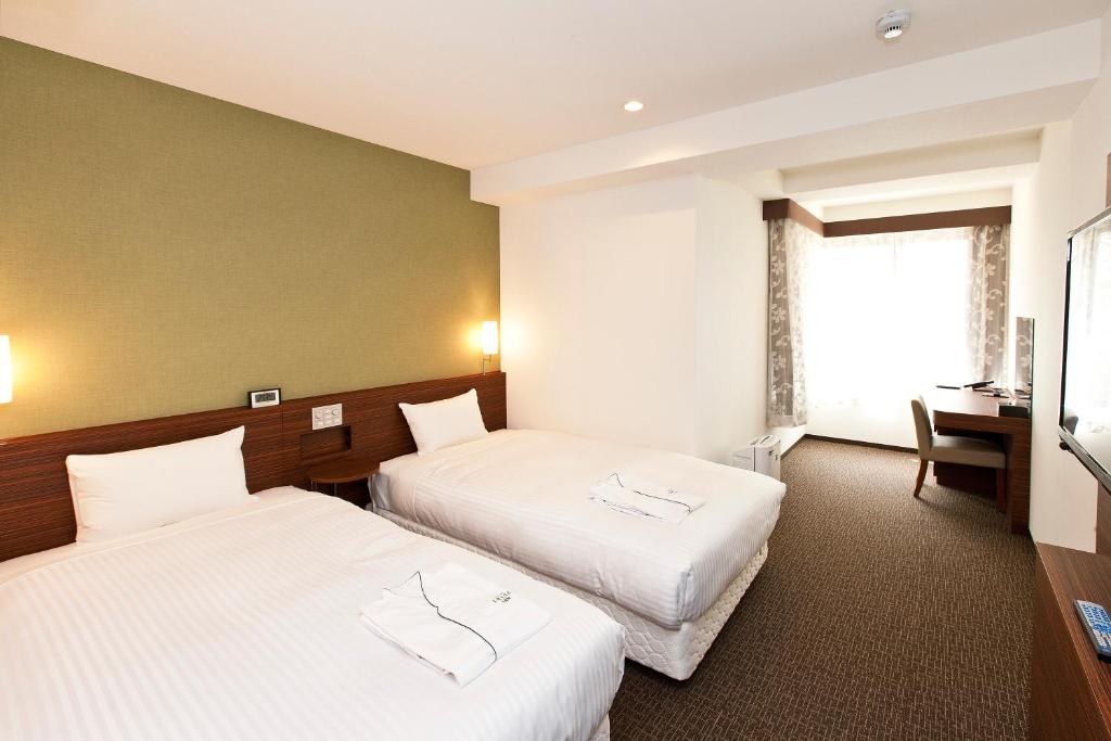 Postel nebo postele na pokoji v ubytování Sotetsu Fresa Inn Tokyo Tamachi