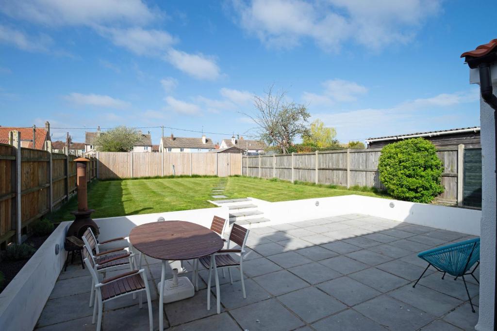 a patio with a table and chairs and a fence at Avocet House in Wells next the Sea