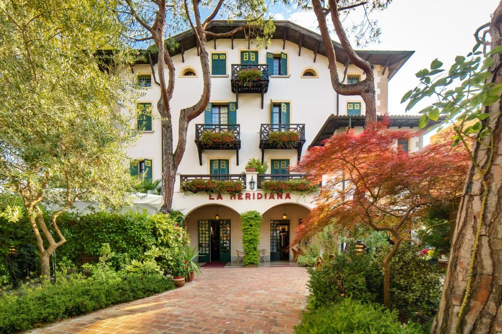 ein großes weißes Gebäude mit Blumenkästen an den Fenstern in der Unterkunft Hotel La Meridiana in Lido di Venezia