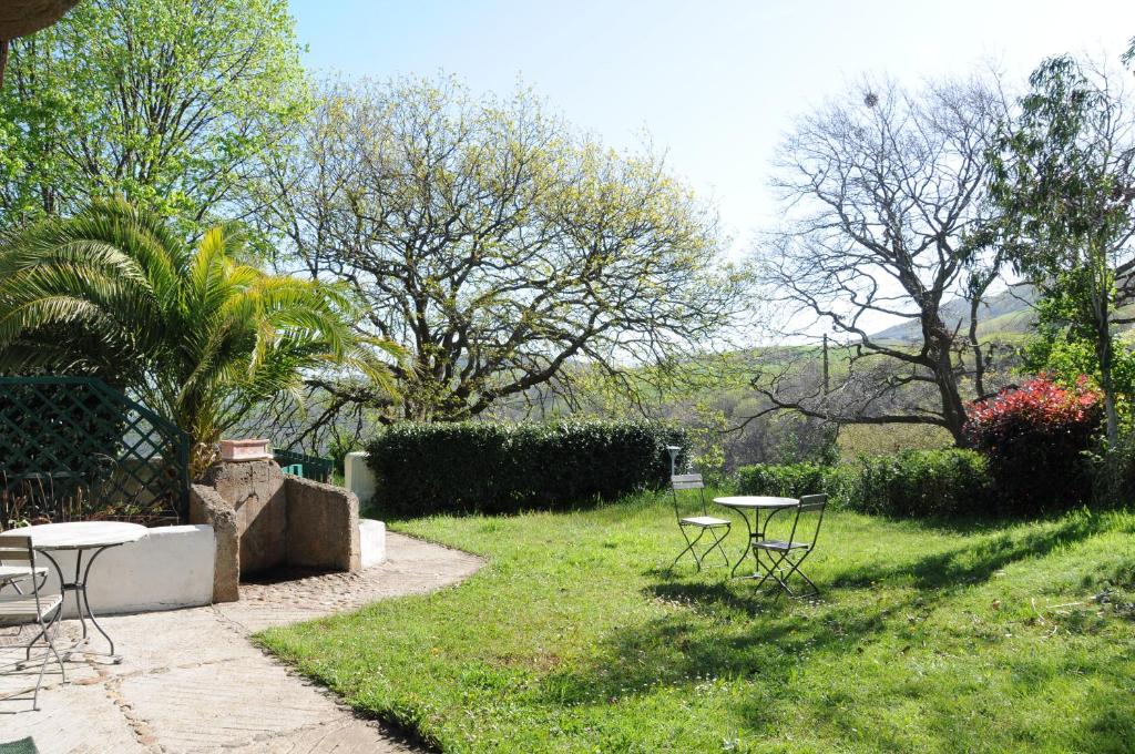 a garden with tables and chairs in the grass at Domaine Xixtaberri in Cambo-les-Bains