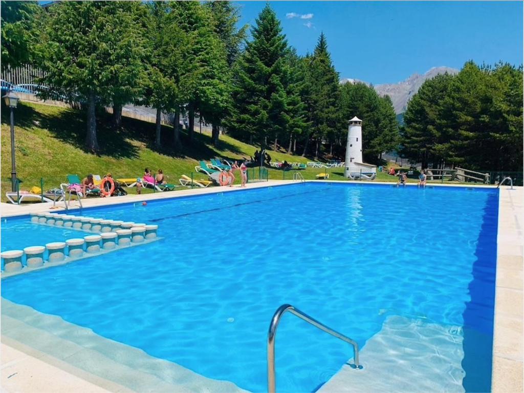 a large swimming pool with a lighthouse in the background at Anayet Sweet Home in Formigal